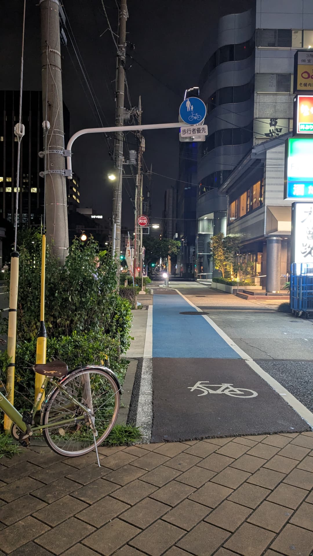 Blau markierte Radspur in einer japanischen Stadt bei Nacht